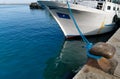 Cleat with blue hawser on the blue sea and white boat