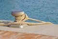 Cleat for mooring boats on wooden platform against a water background Royalty Free Stock Photo