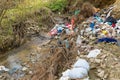 Cleen little creek contaminated with household waste, conceptual human negligence image.