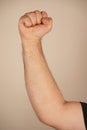 Set against a neutral background, the focus remains on the hand. A clenched fist symbolizes strength, resistance, or