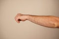 Set against a neutral background, the focus remains on the hand. A clenched fist symbolizes strength, resistance, or