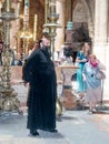 Clergyman stands in the hall in the Church of the Holy Sepulchre and greets visitors in the old city of Jerusalem, Israel.