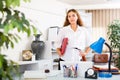 Clerical worker with folder in hands standing in office