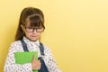 Clever child in eyeglasses holding draw and paint supplies. Kids happy to go back to school. Royalty Free Stock Photo