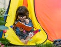 Clever child in eyeglasses holding draw and paint supplies. Kids happy to go back to school. Creative children over yellow backgro Royalty Free Stock Photo