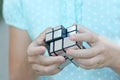 Clever child solves a mirror cube puzzle, a toy in the hands Royalty Free Stock Photo