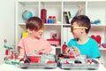 Clever children creating diy construction at the table. Happy boys playing with metal constructor
