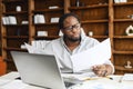 Clever and concentrated African-American guy is doing paperwork