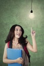 Clever female student pointing at light bulb Royalty Free Stock Photo