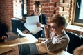 Clever little boss holding a pencil lokoing at the laptop thinking about business Royalty Free Stock Photo