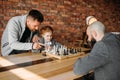 Clever schoolgirl playing chess with man