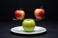 A red apple balanced on a fork above a green apple. Royalty Free Stock Photo