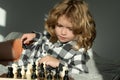 Clever thinking child. Child think about chess game. Intelligent, smart and clever school kid pupil. Games for brain Royalty Free Stock Photo