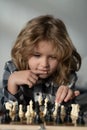 Clever thinking child. Kid thinking about chess. The concept of learning and growing children. Chess, success and Royalty Free Stock Photo