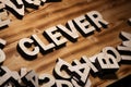 CLEVER word made with block letters lying on wooden board