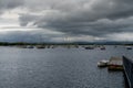 The Rosmoney Pier and dock with many sailboats and yachts anchored in the waters of Clew Bay under an overcast sky