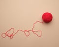 clew with red-woolen thread on a beige background Royalty Free Stock Photo