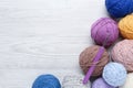 Clews of colorful knitting threads and crochet hook on white wooden table, flat lay. Space for text Royalty Free Stock Photo