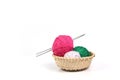 Clews of different colours and knitting needles in wicker basket isolated on white background Royalty Free Stock Photo