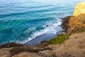 Clff side view of pacific ocean wavy shore and rocks, from sandy iceplant edged path Royalty Free Stock Photo