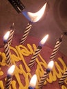 Celebratory birthday candles being lit atop chocolate cake