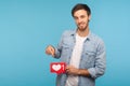 Click Like and subscribe! Portrait of handsome blogger man in denim shirt pointing at social media heart button