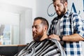 Client of a barber shop getting hairdressing coat Royalty Free Stock Photo