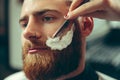 Client during beard shaving in barber shop Royalty Free Stock Photo