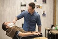 Client getting beard shaving in barber shop