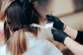 Hairdresser Applying Hair Dye with a Brush in a Salon