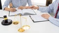 Client with his partner lawyers or attorneys discussing discussing a document or contract agreement working at table in office, Royalty Free Stock Photo