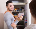 Client and repairman near fridge Royalty Free Stock Photo