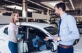 Client and salesman looking at new car