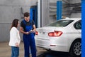 Client talking to car mechanic about car repair Royalty Free Stock Photo