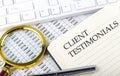 CLIENT TESTIMONIALS text on notebook with chart, magnifier,keyboard and pen Royalty Free Stock Photo
