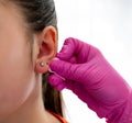 The client& x27;s ear marked by the professional doctor through a point with the help of the special pen for piercing in Royalty Free Stock Photo