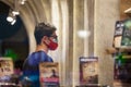 Client, young man, in a bookstore standing wearing two respiratory face masks instead of one in Belgrade, during the coronavirus