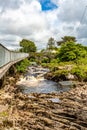 Clifden waterfalls on the Owenglin or Owenglen river with the old Ardbear bridge in the background Royalty Free Stock Photo