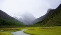 The cliff face was a foggy drop,The small river meandered