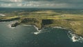 Cliff ocean Ireland shore aerial view: green grassy valley with little farms in Irish countryside Royalty Free Stock Photo