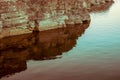 Cliff in an old quarry with reflection in the water.