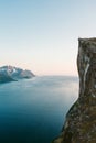 Cliff rock above fjord in Norway man on the edge exploring Senja mountains travel alone hiking adventure Royalty Free Stock Photo