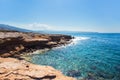 Cliff. Rocky coast of an island in Mediterranean sea. Waves crash on rocks. Blue sky and sea. Royalty Free Stock Photo