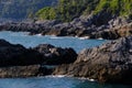 Cliff by the sea in the village of Tellaro di Lerici, near the Cinque Terre. Waves of the blue sea break on the rocks. Royalty Free Stock Photo