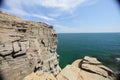 Cliff on spring time with the deep blue sea and sky with clouds Royalty Free Stock Photo