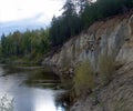 The cliff in the woods North of the river in Yakutia, Kempendyay with spruce forest. Royalty Free Stock Photo