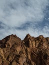Cliffs against the sky, an old brown mountain peak, bare and rocky, Royalty Free Stock Photo