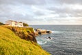 Cliffs by the Atlantic ocean in fishermans village Lagoa, Sao Miguel Island, Azores, Portugal. Traditional houses on the Royalty Free Stock Photo