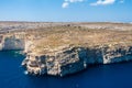 Cliffs and blue lagoons of Gozo seen from above. Aerial view of Gozo, Malta. Dome of Rotunda of Xewkija dominates the island. Royalty Free Stock Photo