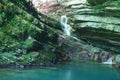 Cliffs covered with ivy and moss with flowing little waterfall